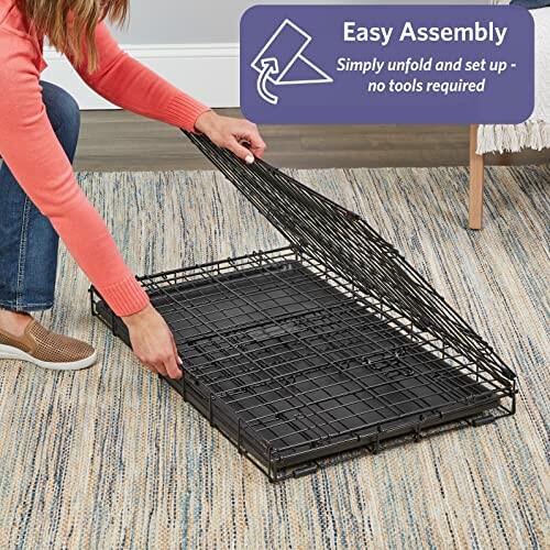 Person assembling a foldable pet crate on a rug.